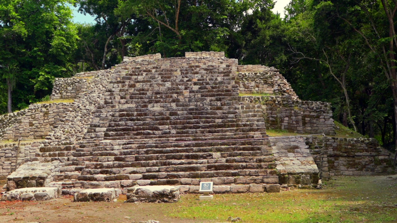 Antica struttura piramidale Maya e altare centrale presso la storica Zona Archeologica di Oxtankah, circondata da alberi lussureggianti