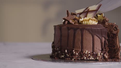 primer plano de una persona en casa cortando una rebanada de pastel de celebración de chocolate en la mesa 3