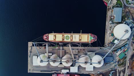 bulk cargo vessel docked at industrial grain terminal - dramatic top down view