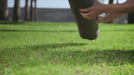 woman hands rolling up yoga mat after training in park.girl folding mat on grass