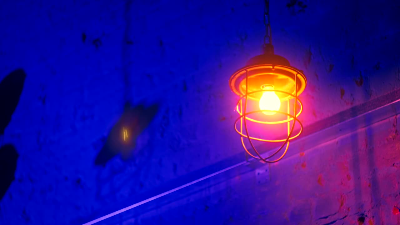 지붕에서 매달린 금속 가노피의 전구가 바람에 흔들리고 있습니다.