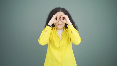 mujer joven con binoculares mirando hacia otro lado.