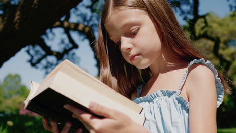 young girl reading a book in a park