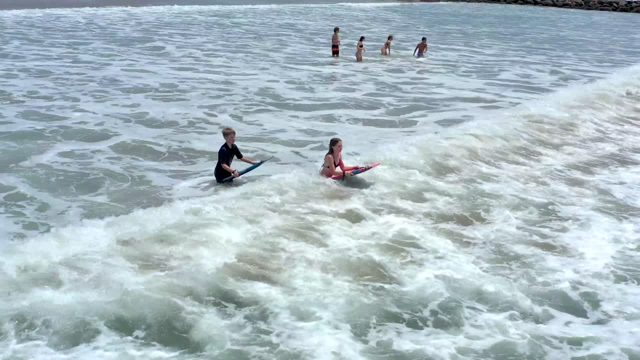 niños practicando bodysurf en ventura, california beach