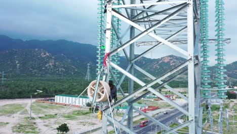 aerial drone footage of high-voltage power towers with prefabricated glass insulators to distribute electricity in an industrial park - development and urbanization concept