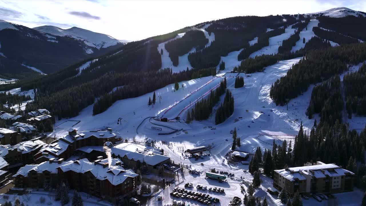 Morning sunrise winter solstice Copper Mountain Resort aerial drone Center village chairlifts gondola Ikon Pass Alterra snowboarding snow ski riding trails December halfpipe trees forward slowly