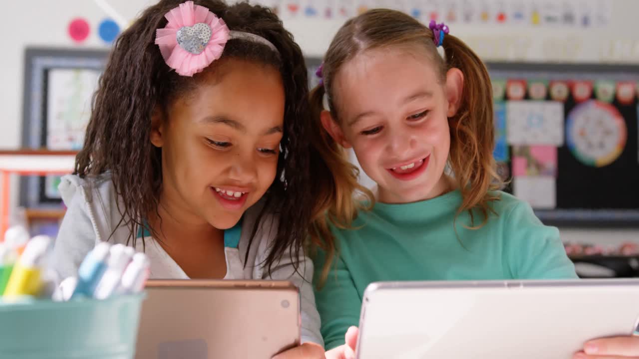 Front view of mixed-race schoolgirls studying on digital tablet in the classroom 4k