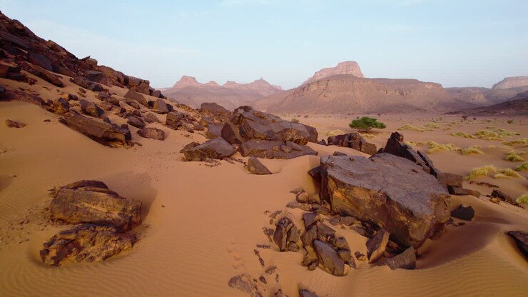 Kalliot punaisessa autiomaassa auringonlaskun aikaan Djanetin keitaalla Algeriassa, Pohjois-Afrikassa.