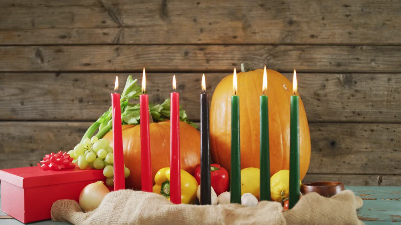 composición de siete velas encendidas y calabazas de halloween, regalos y verduras