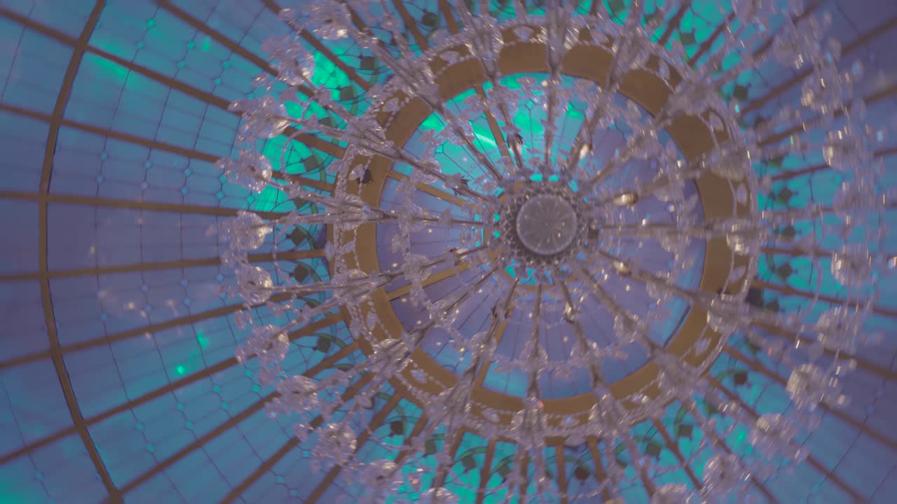 imagen giratoria de un candelabro de vidrio multicolor etérico en la celda de un espacio de eventos