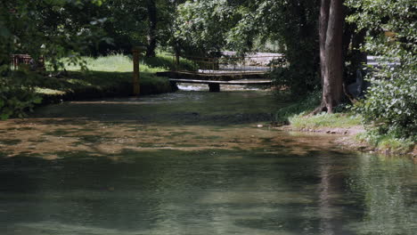 a beautiful river streaming in the town, having a pedestrian bridge