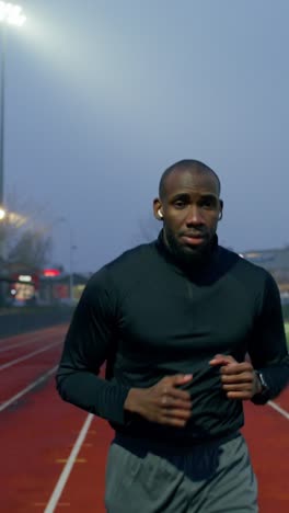 man running on a track at night