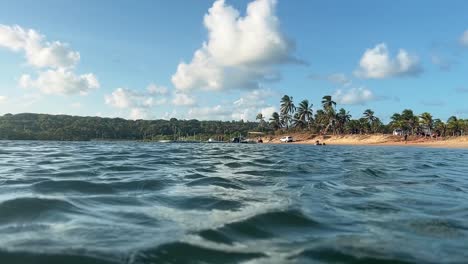 Hermoso-Paisaje-Tomado-Desde-El-Interior-Del-Río-Catu-Tropical-Con-Pájaros-Volando,-Palmeras,-Arena-Dorada-Y-Turistas-En-Cuatriciclos-En-El-Pueblo-De-Playa-De-Sibauma-En-Rio-Grande-Do-Norte,-Brasil