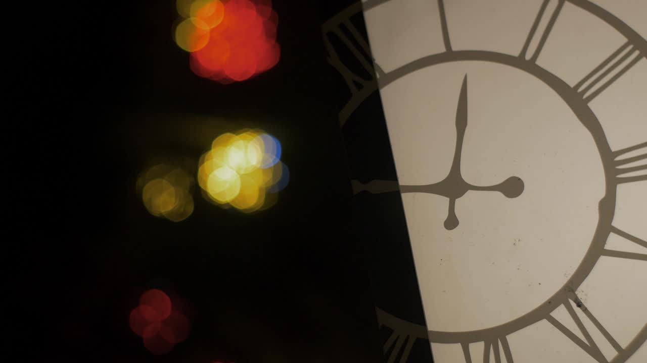 Outdoor Christmas decorations lantern with clock overlay, blured Christmas lights flashing in background, closeup