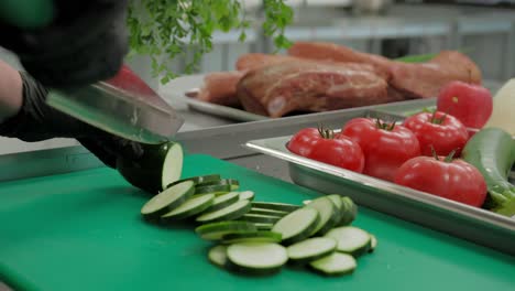 close-up of a chef's hands carefully slicing a zucchini in slow motion to prepare a gourmet dish