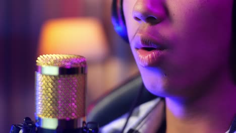 close up of a boy speaking to microphone. room with rgb led strip light