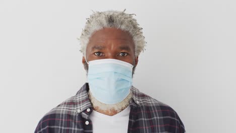 Senior-man-wearing-face-mask-against-white-background