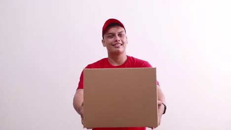 friendly young asian courier boy standing while giving or offering cardboard