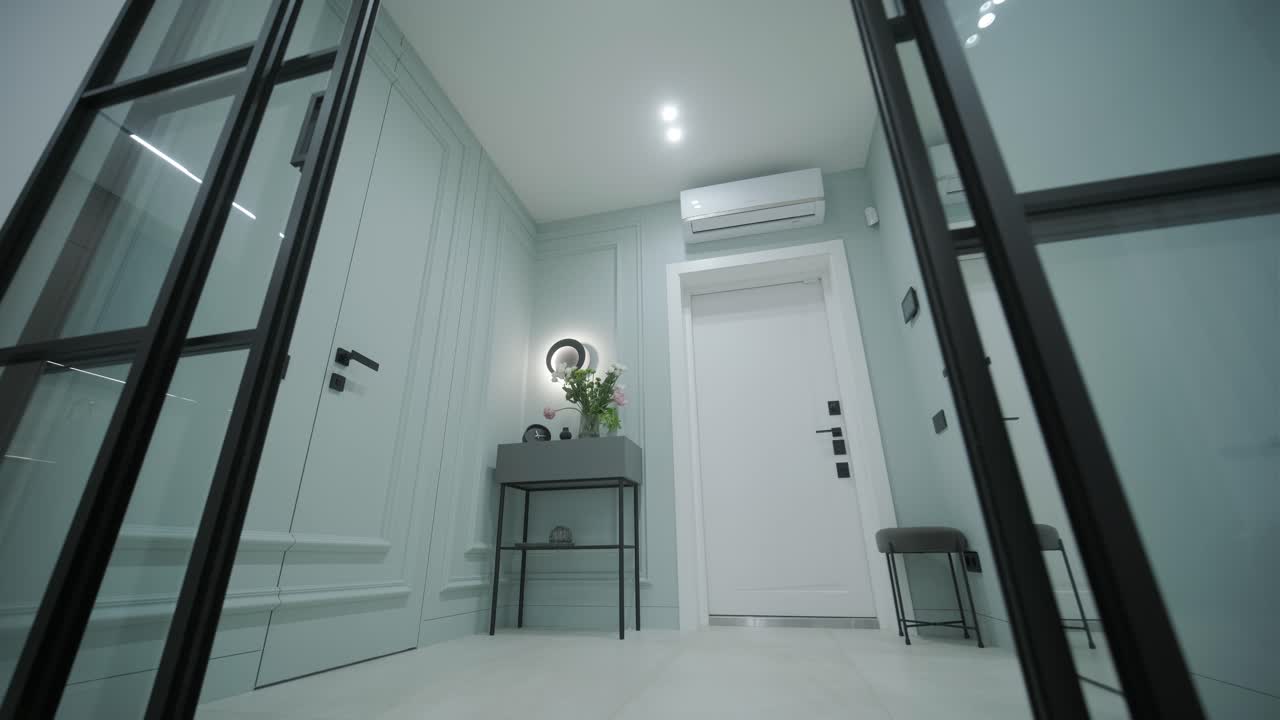 entrada moderna con elegantes puertas de vidrio con marco negro