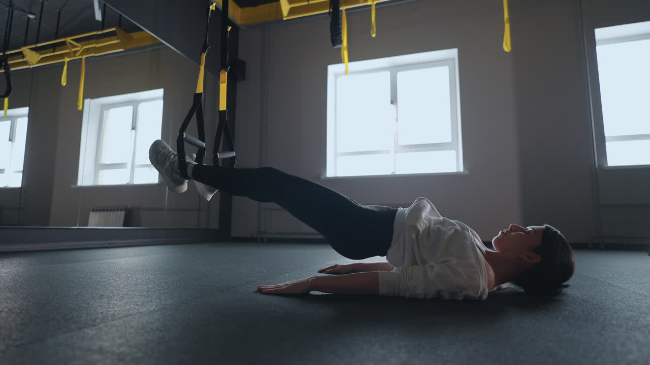 mujer deportiva haciendo ejercicios de trx en el gimnasio. mujeres entrenando con correas de fitness en el gimnasio. mujer hermosa ejercitando sus músculos con correa o correas de suspensión.