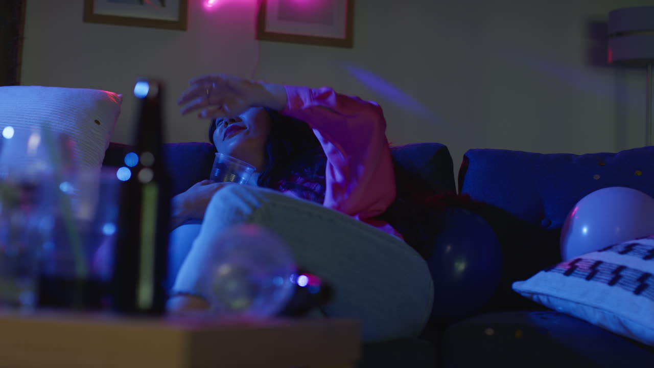 mujer borracha tendida en el sofá bebiendo alcohol en la fiesta de la casa 3