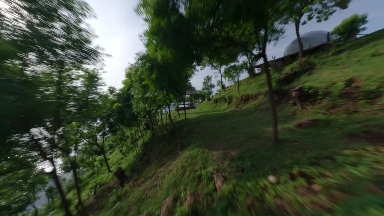 un rápido dron fpv disparó entre árboles en el campamento de bukit asah a una mujer rubia columpiándose en un columpio con una gran vista del océano