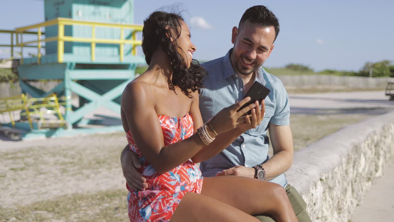pareja emocionada tomando selfie en el paseo marítimo