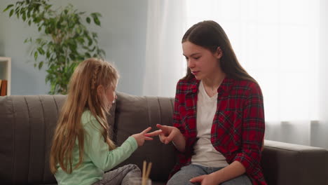 Elder-and-junior-sisters-play-scissors-paper-at-home