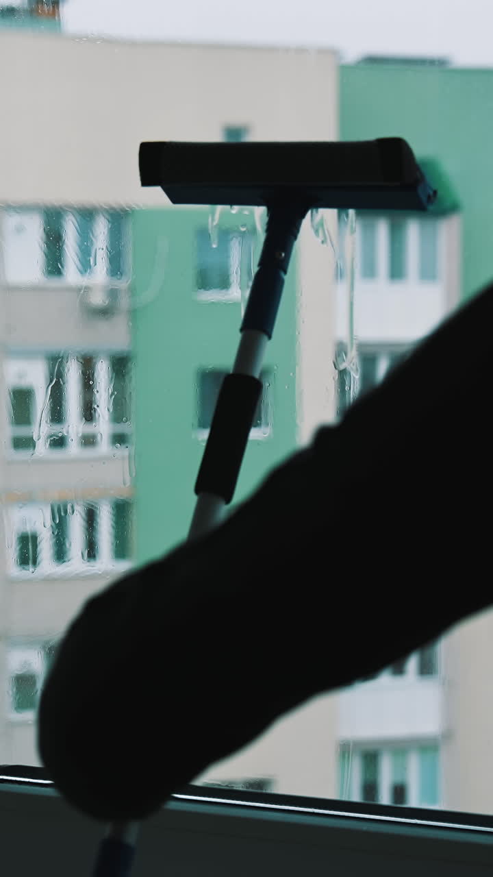 Glass cleaning professioanl worker. Window cleaning indoor interior. Vertical video