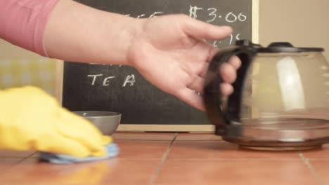 manos con guantes de goma limpiando la mesa de la cafetería plano medio