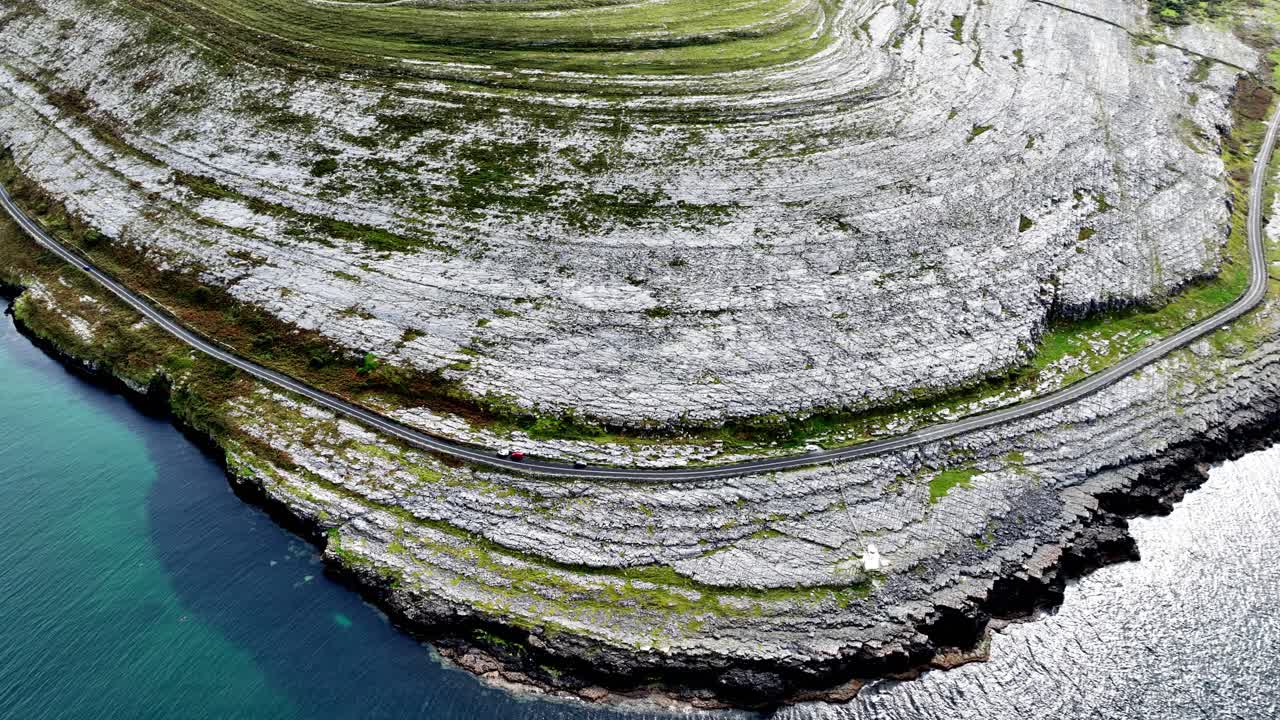 Aerial View of a Coastal Road Winding Along Dramatic Cliffs in Ireland
