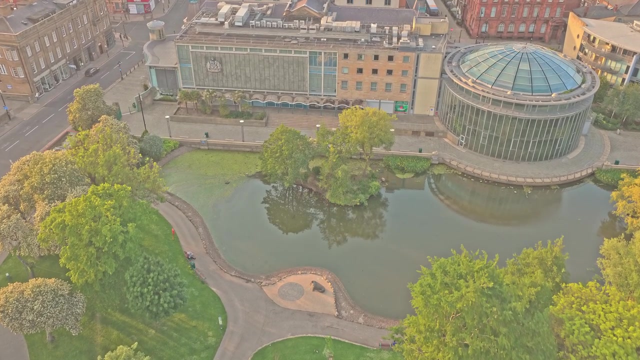 Mowbray Park e il centro città di Sunderland a Sunderland, Tyne and Wear, Inghilterra, con il Sunderland Museum e i Winter Gardens, un parco consolidato e lo skyline urbano circostante, sorvolo in avanti con drone