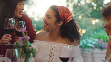 young friends celebrating at dinner party asian woman greeting her friend with hug enjoying reunion gathering sitting at table outdoors 4k footage