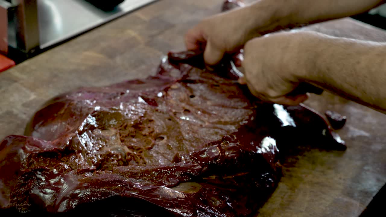 Nestled in a cozy kitchen, a skilled chef meticulously prepares a fresh cut of meat, showcasing techniques passed down through generations while emphasizing tradition and culinary craftsmanship