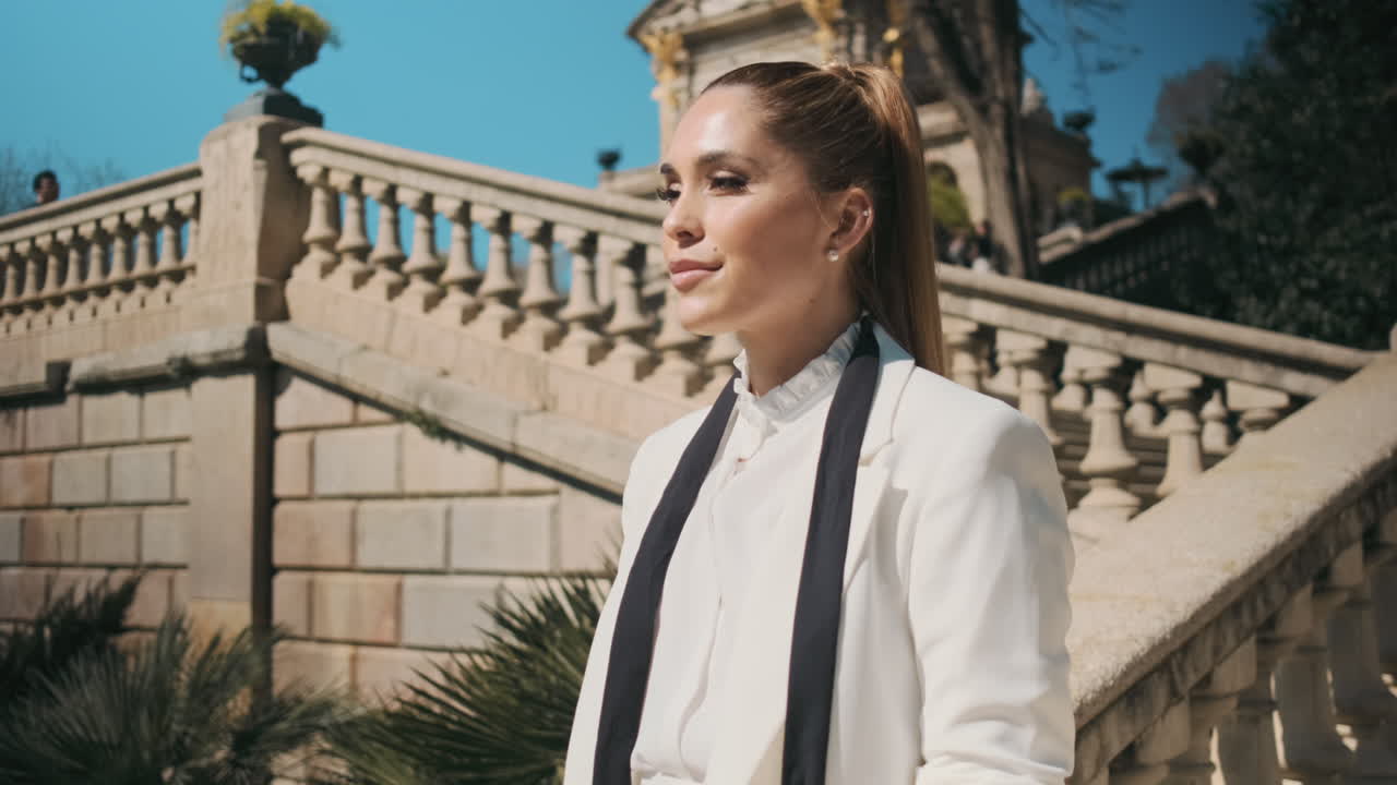 una joven elegante de pie al aire libre.