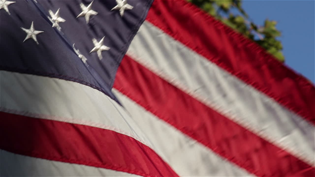 Primo piano della bandiera americana che sventola in una leggera brezza alla luce del sole serale.