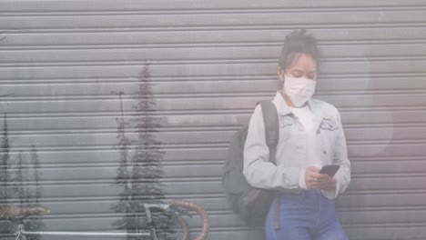 Animación-De-Una-Mujer-Con-Mascarilla-Usando-Un-Teléfono-Inteligente-Con-Un-Paisaje-Invernal