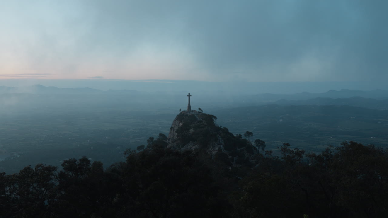 Majestic cross atop hill in Mallorca, Spain. Stunning panoramic landscape. Perfect for spiritual or travel documentaries.
