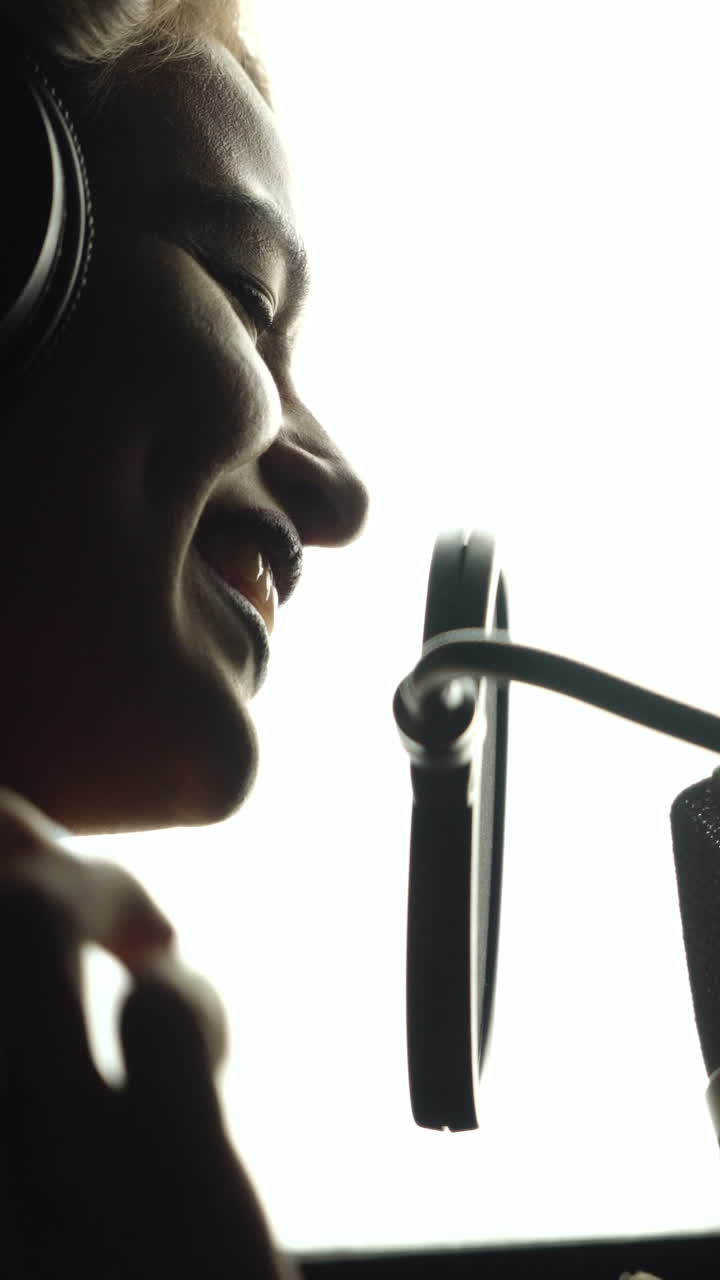 Beautiful young singer who recorded a song in a professional recording studio. Female vocal Vertical video