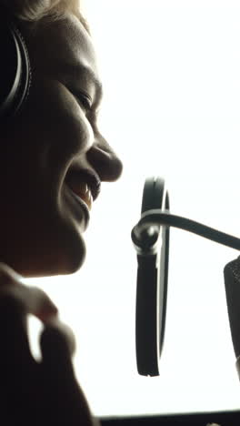 beautiful young singer who recorded a song in a professional recording studio. female vocal vertical video