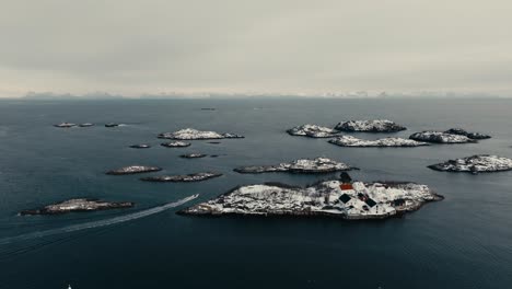 snow-covered fishing village of henningsvaer during winter in norway. aerial drone shot