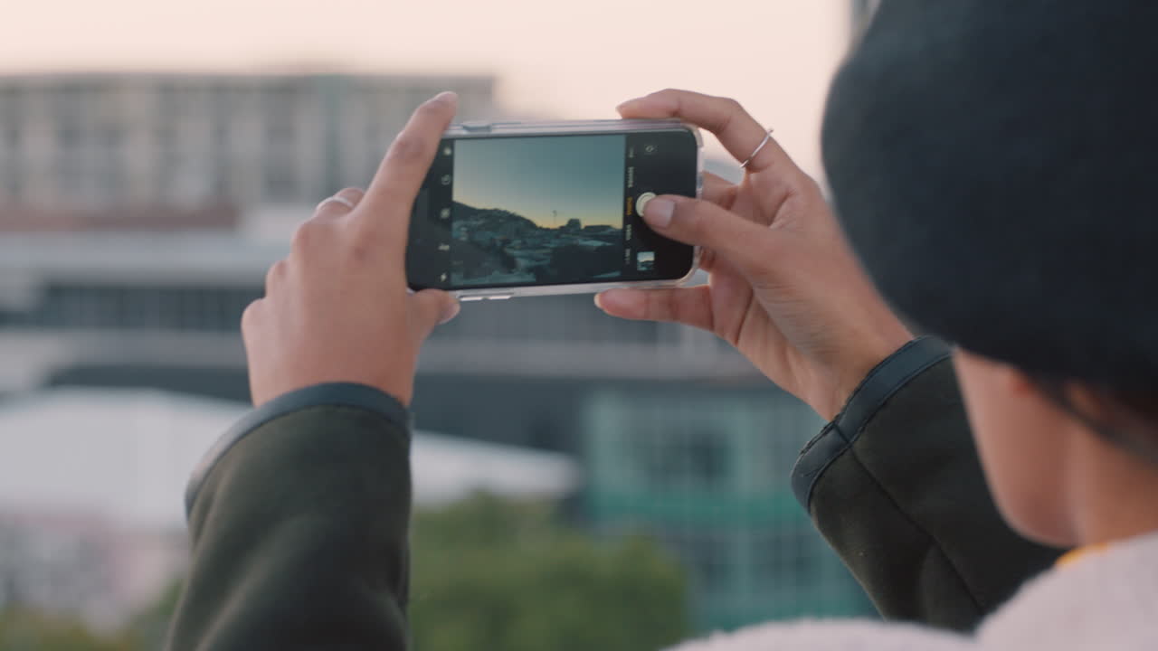 mujer joven tomando fotos de la ciudad usando una cámara móvil de teléfono inteligente disfrutando de hacer turismo compartiendo fotos de vacaciones en las redes sociales