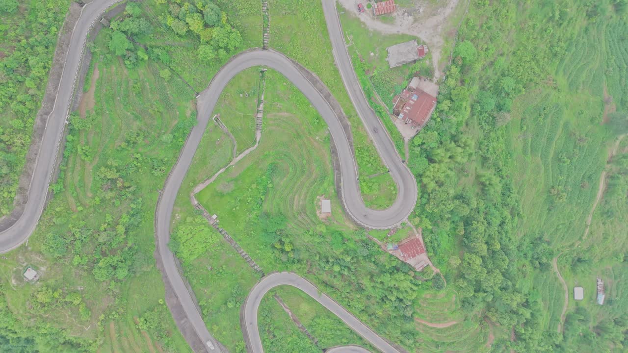 A smooth black-topped road cuts through the mountainous landscape, connecting remote areas and offering scenic views of nature, elevation, and rural infrastructure in Nepal’s highland regions.