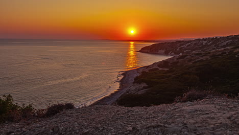 an orange sunset over a bay on the island of cyprus