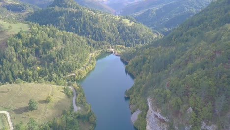 Long-4k-ascending-aerial-shot-of-small-lake-in-mountains,-summer-day