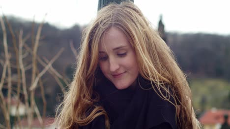 caucasian woman drawing or writing into paper notepad, exterior face closeup, windy hair