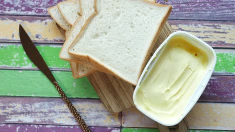 fresh butter in a container with bread on white background