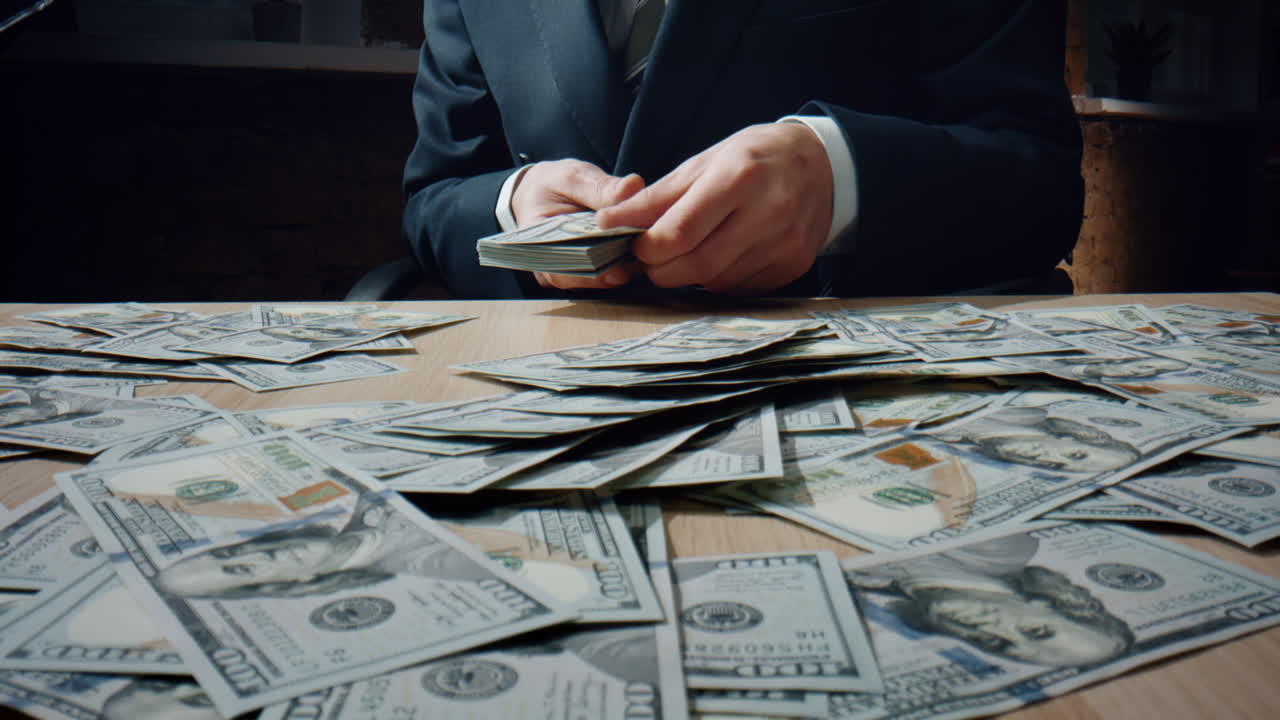 Man counting heap dollars at office desk close up. Calculating american money.
