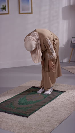 Vertical-Video-Of-Muslim-Woman-Wearing-Hijab-At-Home-Praying-Kneeling-On-Prayer-Mat-4