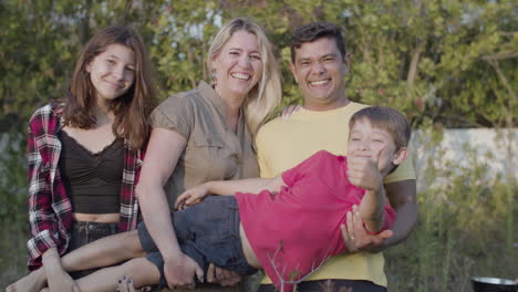 happy family holding preteen boy, looking at camera and smiling